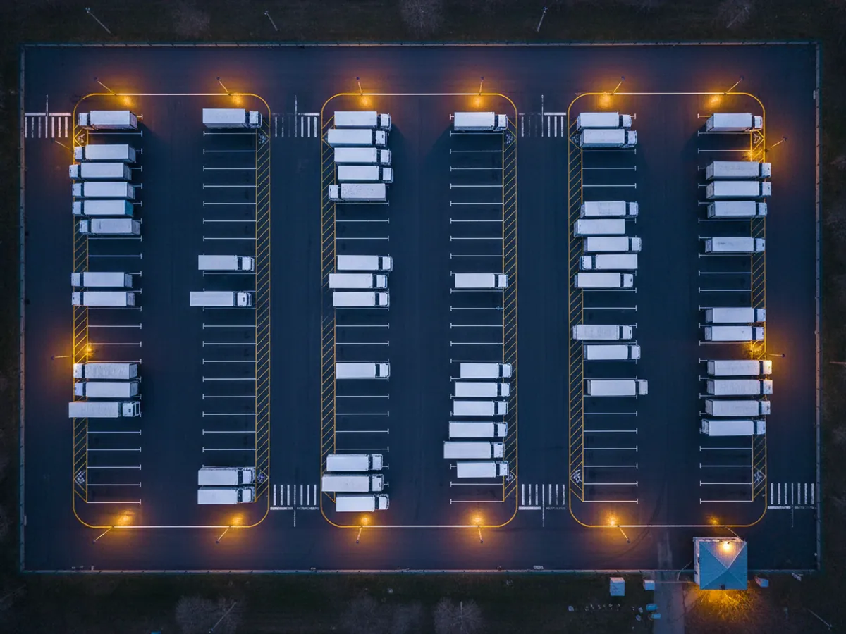 Lorries in a depot yard standing in three separate groups, seen from above